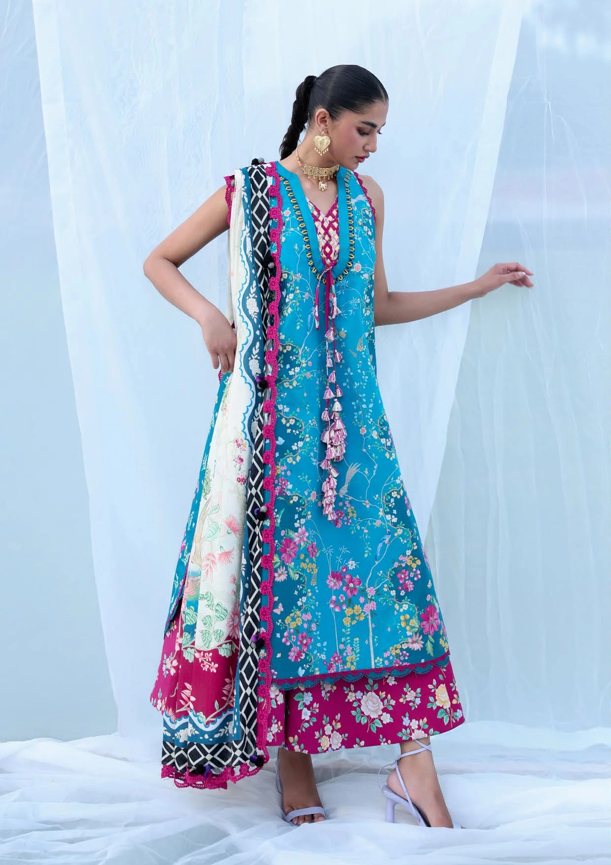 Unstitched lawn ensemble in a striking teal blue tone, adorned with intricate chinoiserie-inspired motifs that evoke an air of timeless elegance. Paired with a deep cherry printed trouser and a beautifully flowing ivory voile dupatta featuring whimsical garden elements, this light and graceful outfit is perfect for summers. Crafted through delicate digital prints, the ensemble blends artistic charm with effortless sophistication. Unstitched lawn ensemble in a striking teal blue tone, adorned with intricate chinoiserie-inspired motifs that evoke an air of timeless elegance. Paired with a deep cherry printed trouser and a beautifully flowing ivory voile dupatta featuring whimsical garden elements, this light and graceful outfit is perfect for summers. Crafted through delicate digital prints, the ensemble blends artistic charm with effortless sophistication.